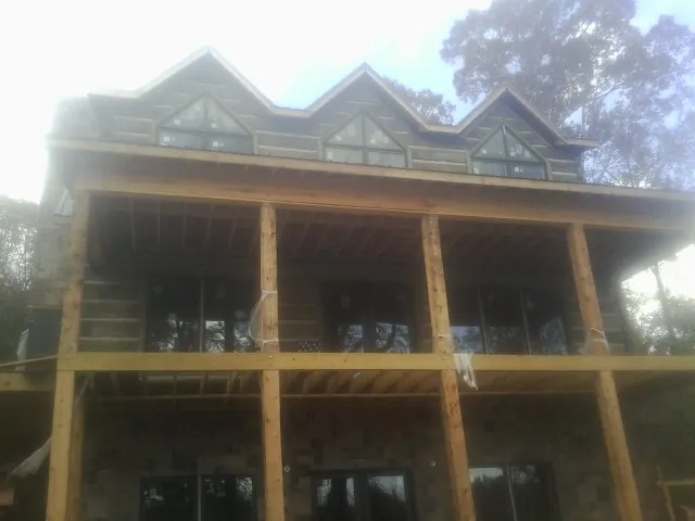 Dormers and porch framing on a large log home under construction — Roof Coating work by our crew in Sharpsburg