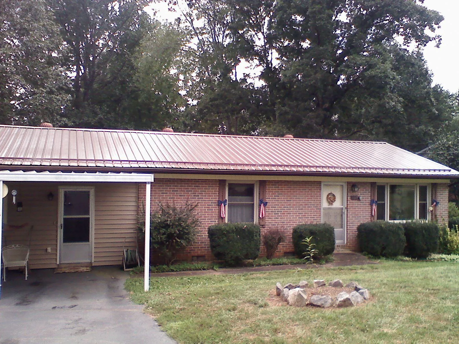 Bronze metal roof and carport on a brick ranch home — Roof Repair work by our crew in Sharpsburg